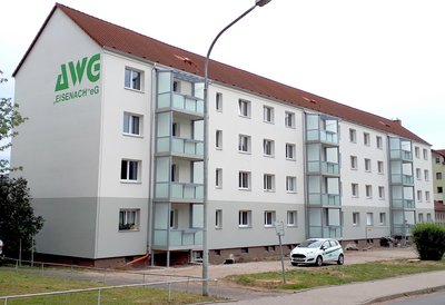 Wohnkomplex mit Balkons und AWG-Logo an der Fassade
