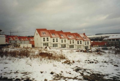 Neubauwohnungen vor einem schneebedeckten Feld
