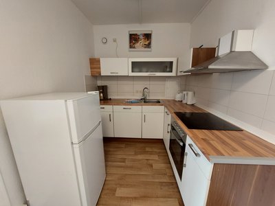 Küche mit großer Küchenzeile und freistehenden Kühlschrank