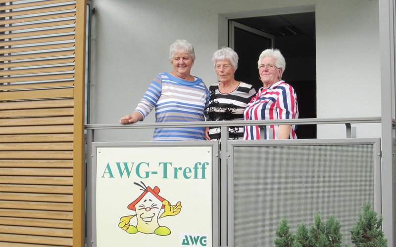 3 ältere Frauen schauen von einem Balkon