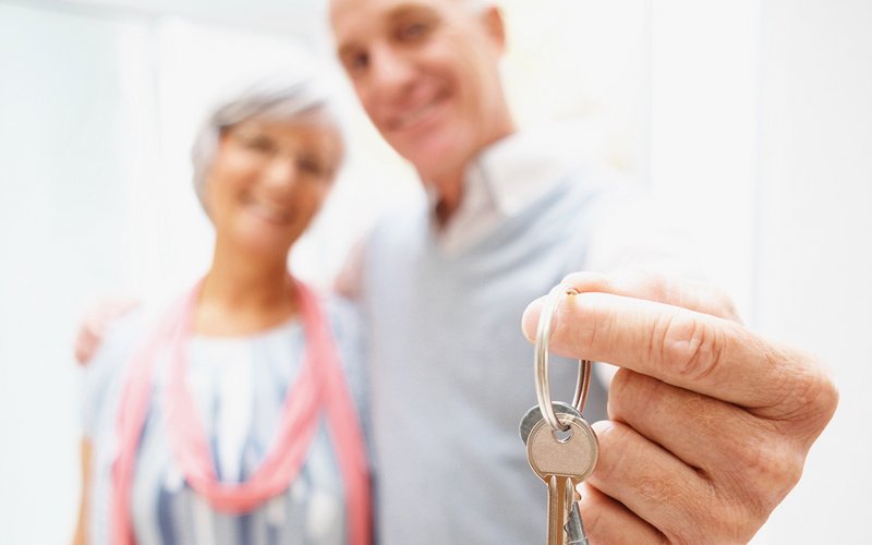 Älteres Paar hält den Wohnungsschlüssel in der Hand