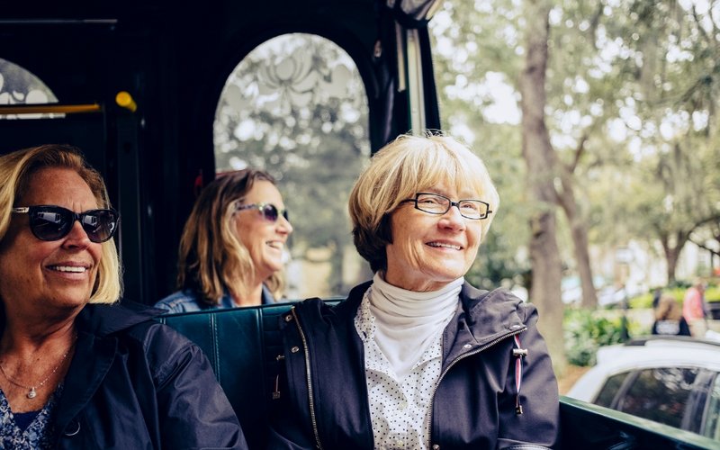 Zwei ältere Damen sitzen in einem Bus und schauen aus dem Fenster